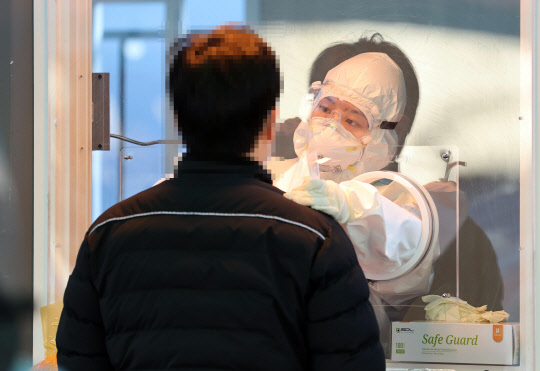 오는 20일 국내에서 신종 코로나바이러스 감염증(코로나19) 첫 확진자가 나온 지 꼭 1년째가 되는 가운데 19일 오전 서울역 광장에 마련된 임시 선별진료소에서 의료진이 검체를 채취하고 있다. 연합뉴스